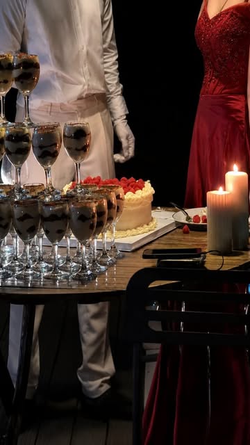 Service du soir par Eterna Event : pyramide de verrines au chocolat dressées une par une, gâteau aux framboises, bougies allumées et maître d'hôtel en veste blanche et gants